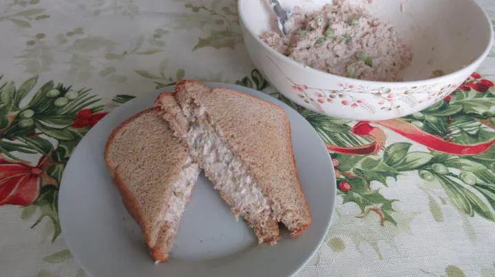 A tuna salad sandwich with a bowl of tuna salad