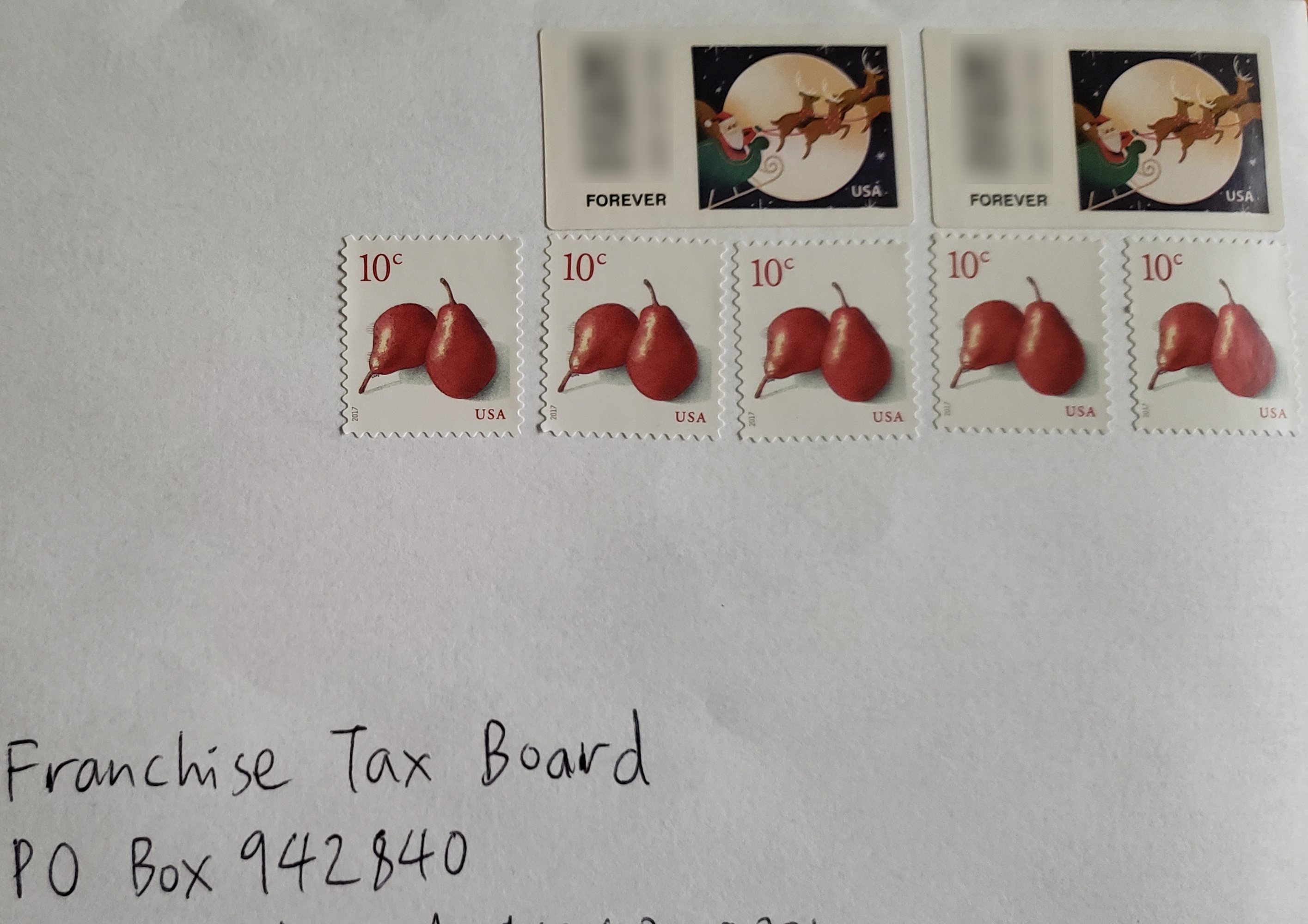 Envelope with multiple postage stamps, including two Forever stamps and five 10-cent stamps